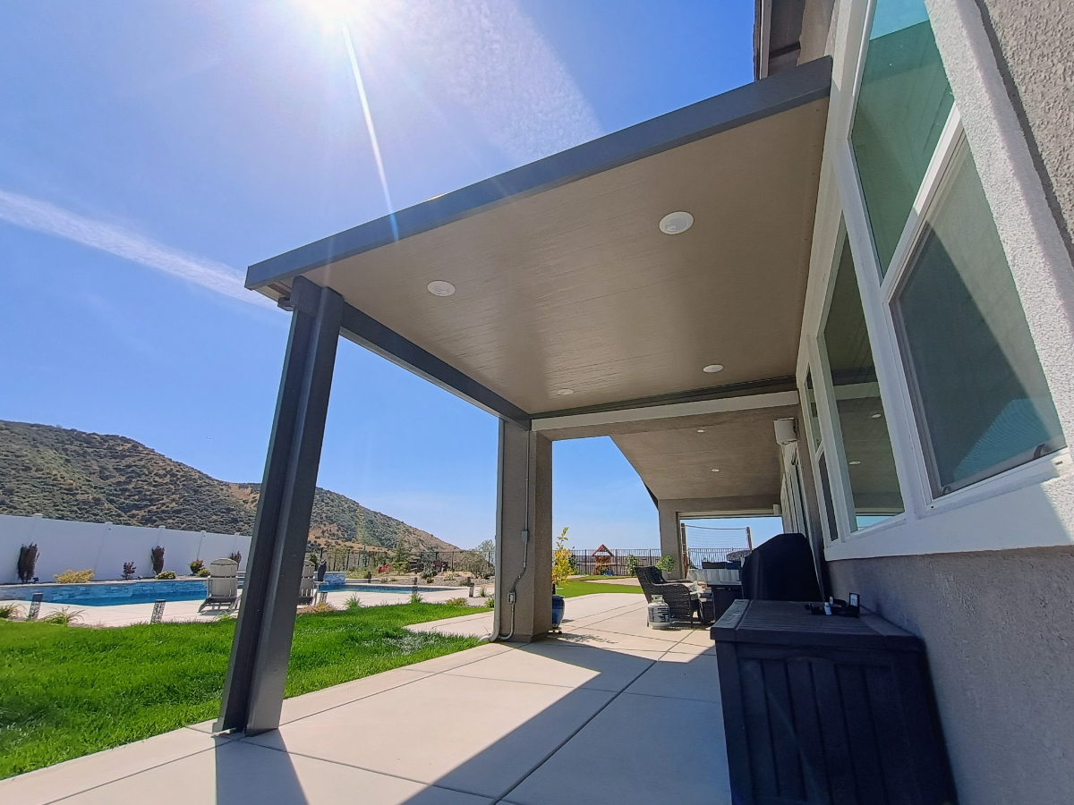 Wood-grain aluminum patio cover providing covered outdoor dining space
